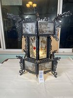 Front view of the Asian style lamp on display, showing its ornate dragon-themed frame and hand painted glass panels.