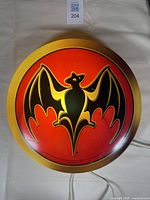 Top-down view of the Bacardi bat logo bar light on a flat surface showing logo and gold trim.