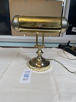 Front view of the brass banker desk lamp showing the perforated shade design and base.