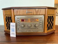 Front view of the wooden AM/FM radio console with speaker grilles and control panel visible.