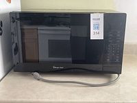 Front view of the black Magic Chef microwave showing the door and control panel with keypad and digital display.