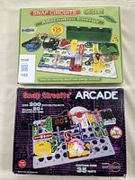 Two unopened Snap Circuits sets: Green Alternative Energy and Arcade, showing box fronts.