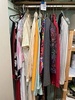 Full rack showing assorted vintage women’s jackets, blouses, dresses, skirts