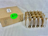 25-pack of LED filament bulbs in original cardboard box with green sticker #52, bulbs removed from tray and displayed front facing showing faceted clear glass design and metal E17 bases.