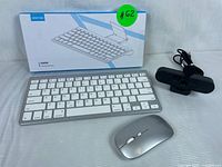 Wireless keyboard, wireless mouse and webcam with box in background