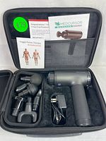 Medcursor muscle massager and accessories neatly placed in black carrying case with user manuals visible.