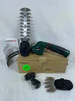 PosenPro cordless grass shear with two detachable blades, battery pack, charger, instruction manual, and cardboard box visible on white background.