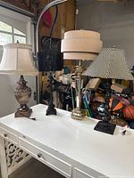 Four lamps displayed on a white desk showcasing different sizes and styles