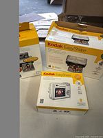 Photo showing the Kodak EasyShare printer dock series 3 box, color cartridge & photo paper kit box, and Kodak EasyShare C330 camera box together.