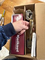 Photo of exterior door handle and deadbolt set in original Kwikset box with manual.