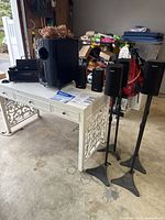 Complete Onkyo surround sound speaker system including all speakers, subwoofer, cables, and head unit shown on a white decorative table indoors.