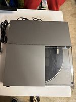 Top view of the silver turntable showing branding and model number 'Realistic LAB-2200 Linear Tracking Logic Controlled Automatic Turntable'. Powers cord attached.