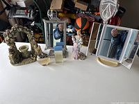 Vanity items on table with mirrors, perfume bottles, figurines, and candle holder