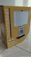 Box of transitional style table lamp with photo frame, showing product image and details in multiple languages.