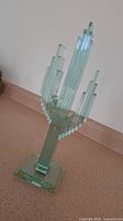 Front view of the clear glass cactus sculpture showing the stacked glass panels and base.