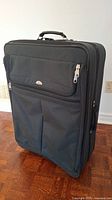 Front view of the large dark green Samsonite rolling suitcase showing two zippered compartments and top handle
