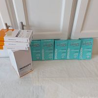 9 boxes of Mighty Patch Nose and 5 boxes of Proactiv Zits Happen patches lined up against a white door, showing full lot.