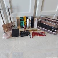 Full lot overview of cosmetics displayed on table showing individual boxed items and makeup bag.