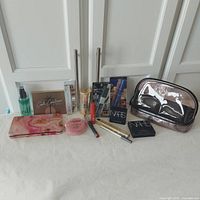 Full display of all makeup and cosmetic items in the lot, showing packaging and bag