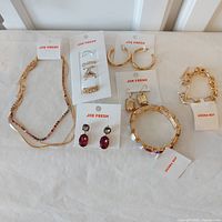 Full lot overview showing all jewelry items including necklaces, earrings, rings, and bracelets with Joe Fresh tags.