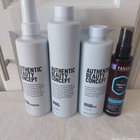 Photo showing all four hair care products for dry hair including three Authentic Beauty Concept bottles and one Hask Argan Oil bottle.