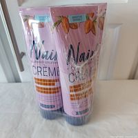 Four tubes of Nair sensitive hair removal cream, sealed in plastic wrap, showing front of tubes with product branding and almond images.
