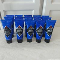 Photo showing the front view of fifteen blue tubes of Jack Black Beard Lube Conditioning Shave standing up, all sealed and brand new.