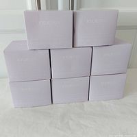 Eight light lavender square boxes labeled Kylieskin stacked in two rows of four on a white surface.