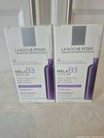 Front view of two boxed La Roche-Posay Mela B3 Serum bottles showing brand, product name, and skin benefits.