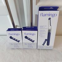 Photo showing all three items in the lot: one dermaplane razor box and two cartridge boxes, all Flamingo brand and sealed.