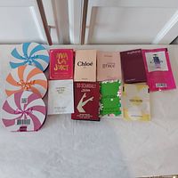 Photo showing all 12 carded fragrance samples arranged in a row on white background including Michel Germain, Juicy Couture, Chloe, Philosophy, Calvin Klein, Prada, Elizabeth Arden, Jean Paul Gaultier, Marc Jacobs samples.