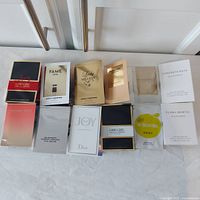 Overview photo showing all 12 packaged fragrance samples laid out flat, clearly displaying brand names and some sample sizes.