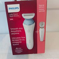 Front of sealed product box showing Philips Lady Shaver 8000 Special Edition, with images of shaver and travel size attachment, and marketing text about smooth skin.