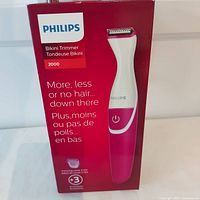 Original boxed Philips Bikini Trimmer model 2000 in pink and white, showing front of packaging with product image and key feature text in English and French.