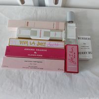 Photo showing the 8 boxed travel size perfumes and eau de parfums arranged on a white surface with visible brand names and product details.