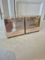 Two sealed gold-colored Lancome Absolue Soft Cream boxes side by side.