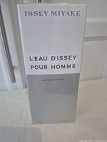 Front view of the boxed and sealed fragrance bottle showing product and brand name.