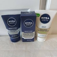 Photo showing Nivea Men Protect & Care Face Scrub, Face Moisturizer in box, and Sensitive Face Wash in tubes with visible product names and packaging