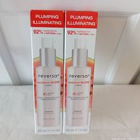 Two boxes of Reversa Radiance-GLOW cream displayed upright, showing front label with product information including 92% natural ingredients, peptide, murunga plum, watermelon extracts, and 4% glycolic acid.