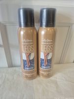Two full bottles of Sally Hansen Airbrush Legs Leg Makeup spray standing side by side showing front labels