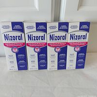 Front view of four sealed boxes of Nizoral 2% Ketoconazole anti-dandruff shampoo in 120ml size.