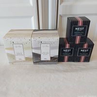 Five scented candles new in box: two Life At Home 198g candles and three Nest 57g candles
