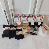 Photo showing entire lot with all socks packages, foot covers, hosiery, insoles, and bra straps on display