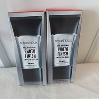 Two boxed tubes of Smashbox The Original Photo Finish Smooth & Blur Primer, 30ml each, positioned side by side on a white surface against a wall.