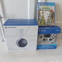Lot contents showing Sony PlayStation Pulse 3D headset box, DualShock 4 controller in box, and Plants vs Zombies PS4 game case.