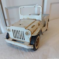 Front angled view of white Tonka Jeep toy showing grille, windshield frame and front tires.