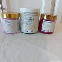 Three jars of Truly brand shave products, varying sizes from 38ml to 120ml, including whipped shave butter, rich shave butter, and pre shave scrub.