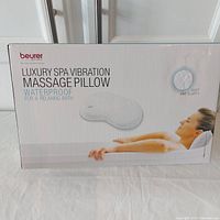 Box front showing product name, brand and image of pillow in use with a woman relaxing in bath.