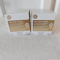 Photo of two boxed Yves Rocher Anti-Age Global skincare products, the day/night cream and night mask, both 75ml each, showing front packaging details and brand.