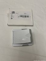 Photo of AUSWAUR wall mount with original white box in background, showing front view of mount.